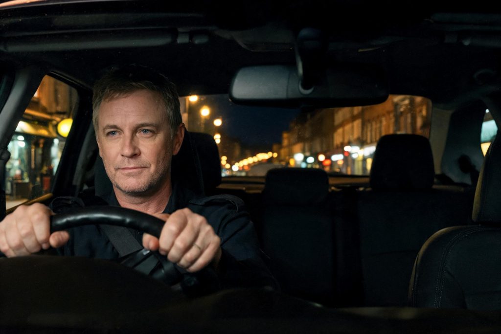 Private hire driver at the wheel of his car at night