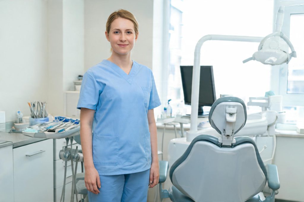 Dental nurse standing beside the dental chair in a UK dental surgery