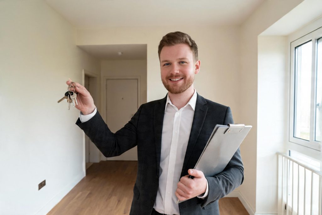 Letting agent with keys and a clipboard in the hallway of a rental flat